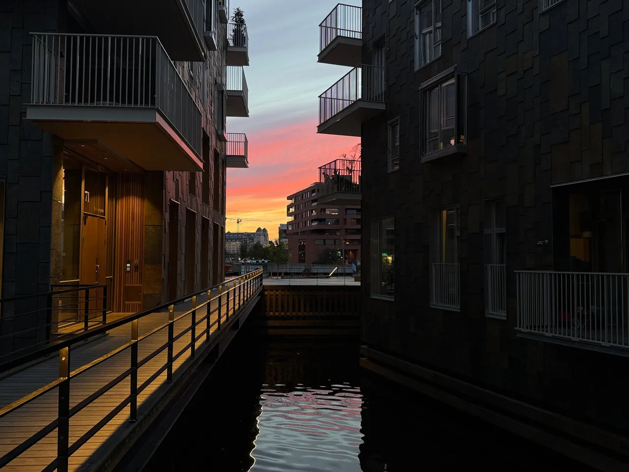 Vannrommet mellom husene i solnedgang, med rød himmel over Bjørvika.